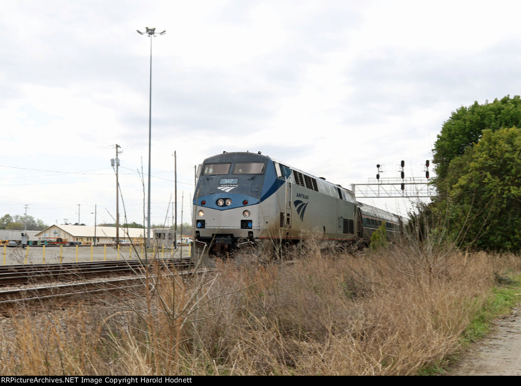 AMTK 147 leads train P080-25 past the signals at DI